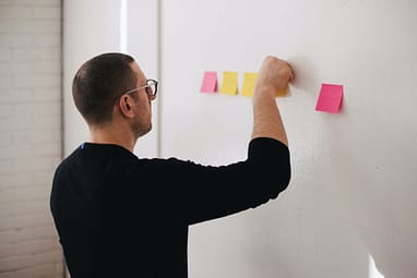 Man putting post-its on a wall